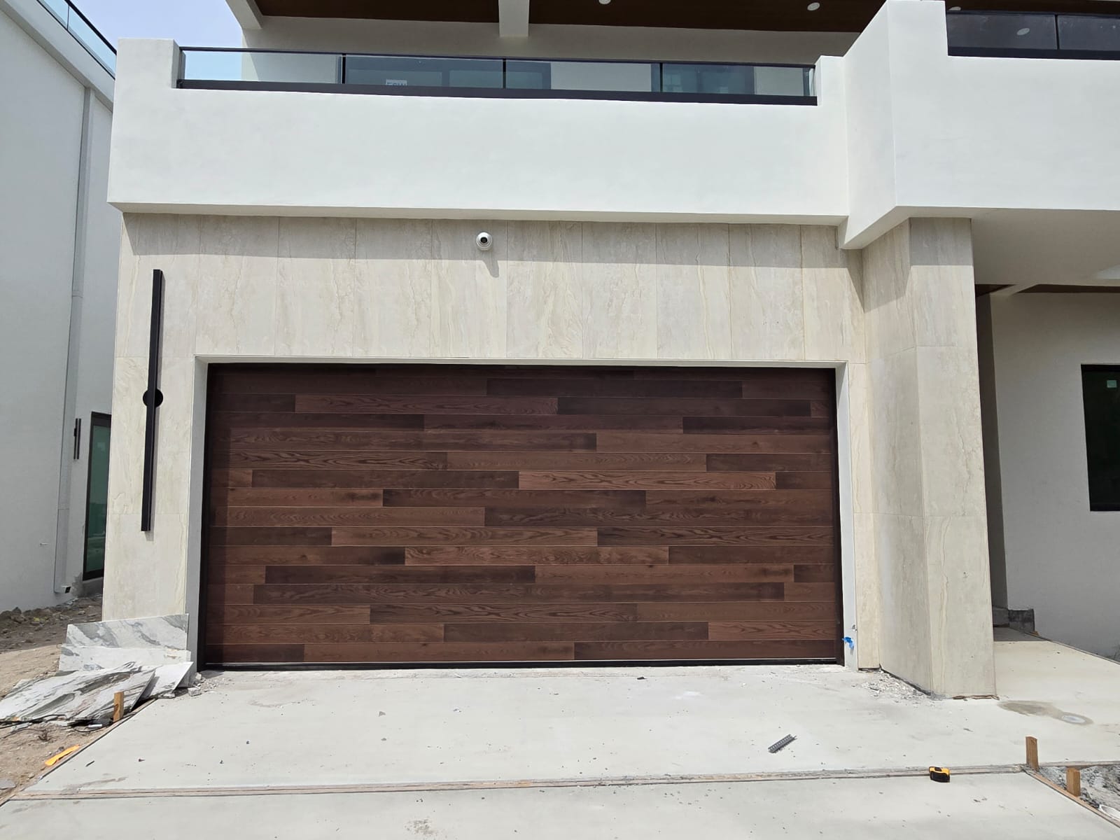 Dark walnut plank wood garage door on a modern South Florida new build