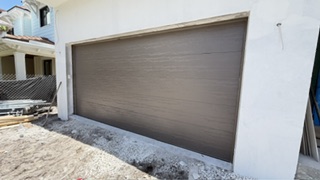 Bronze woodgrain flush garage door on new construction home